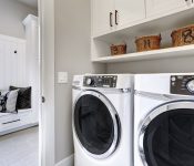 White washing machines in laundry cabinet