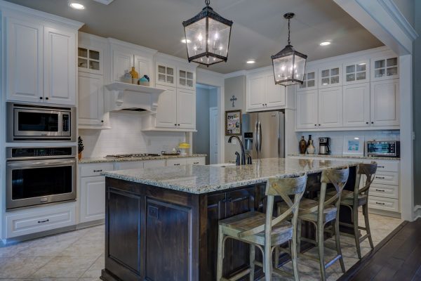 New luxury home kitchen interior with island, sink, cabinets, and hardwood floors