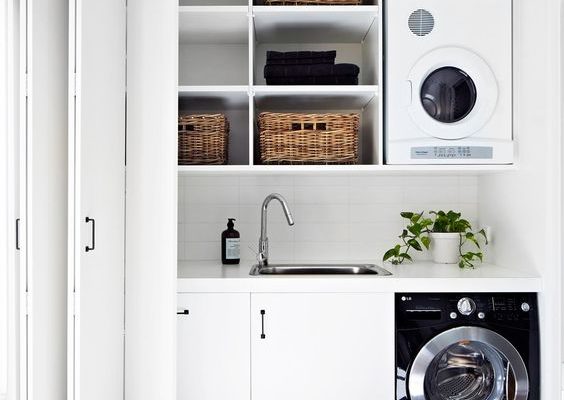 Washing machine in vintage laundry room interior with wooden furniture